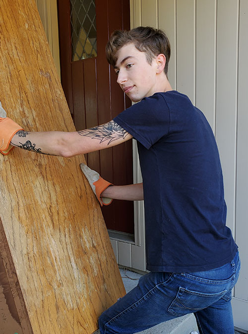 young adult cleaning out furniture from home